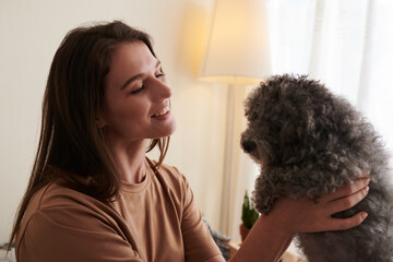 Happy woman interacting with dog, that helps relieve stresss, anxiety and calms emotional wellbeing
