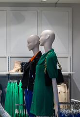 Two white mannequins in a clothing store. White mannequins in a white and black shirt