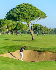Golfer spielt einen Ball aus dem Bunker