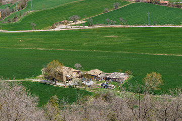 Typical Catalan Masia farm in the countryside with crop fields