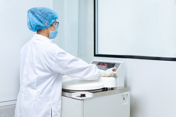 Unidentified operator is prepare the equipment to autoclave and set up parameter for sterilization to prevent contamination, concept of laboratory, microbiology in pharmaceutical industry.