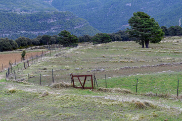 Fenced with gate of a rural farm in the countryside in the mountains
