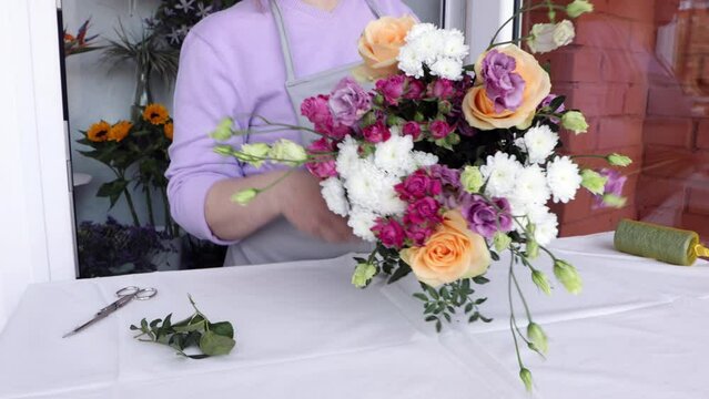 Floral artist working in flower shop studio. Floristry creating bouquet . Small women business concept. Female making flower arrangement.