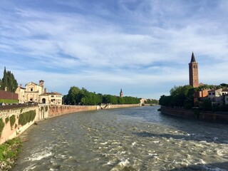 Obraz premium Adige river view from Ponte Pietra. Tower bell of Saint Anastasia church and facades of medieval buildings. Selective focus. Verona, Italy