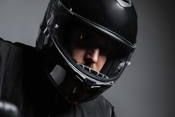 Fototapeta premium Biker in the helmet close up portrait, riding motorcycle, studio shot