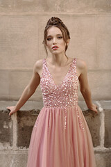 Portrait of beauiful European girl bridesmaid in classic pink dress