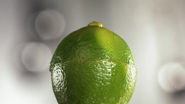 Half Lime falling and splashing on white background. Food levitation concept. Slow Motion