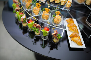 various cold appetizers on a black buffet table close-up