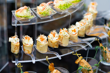 various appetizing cold appetizers on a black buffet table close-up