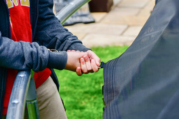 A boy builds a new trampoline at home and stretches the trampoline fabric with springs.