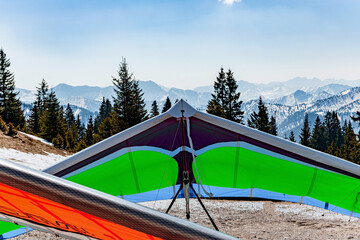 The unfolded hang-glider on the top of the mountain surface is ready for flight.