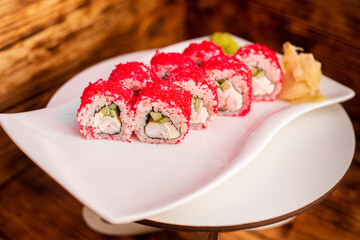Sushi rolls with red caviar and cucumbers on a white plate