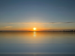 Naklejka na ściany i meble sunset at Baltic sea sun beam and light reflection on water background travel to Estonia