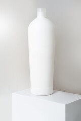 clean bottle of shampoos on a pedestal on a white background