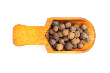Spice Allspice (Jamaica pepper, Pimento) in wooden scoop on white background. Flat lay. Indian...