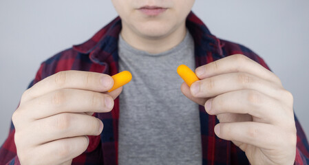 The man puts on earplugs. Close-up of an orange noise barrier. Deep sleep. The ENT doctor advises...