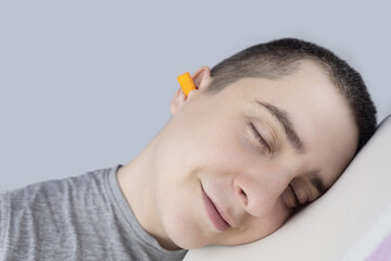The man puts on earplugs. Close-up of an orange noise barrier. Deep sleep. The ENT doctor advises...