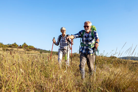 Active old woman and man walking at field and enjoy
