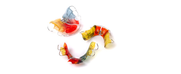 Fototapeta na wymiar Colorful children's orthodontic appliances isolated on white background. Concept of oral health in childhood.