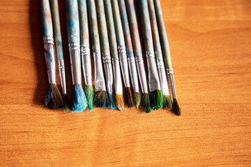 Fototapeta premium schoolchild's brushes for drawing are stacked in a row on the table and ready for the lesson, a blank for the designer