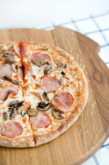 Pizza on a wooden tray and a blue checkered napkin. Foodphoto for pizzeria, menu, catalog, banner, leaflet