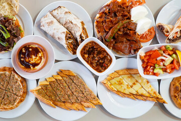 Traditional Turkish cuisine. Pizza, pita, pidesi, sucuk, hummus, kebab. Many dishes on the table. Serving dishes in restaurant. Background image. Top view, flat lay