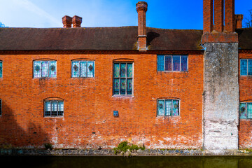 brown brick english country house with moat