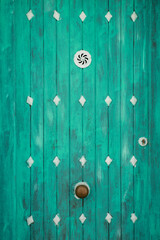 Green wooden door and whitewashed facade in Altea