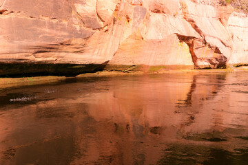 beautiful day on the river, sandstone cliffs and tree reflections in the water, blue sky reflected in the river water