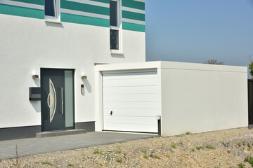 Moderne Beton-Garage mit Automatik-Tor in der Hauszufahrt - obrazy, fototapety, plakaty