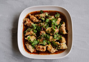 Delicious homemade meal. Spicy Pork Dumplings in Sichuan Mala Sauce.