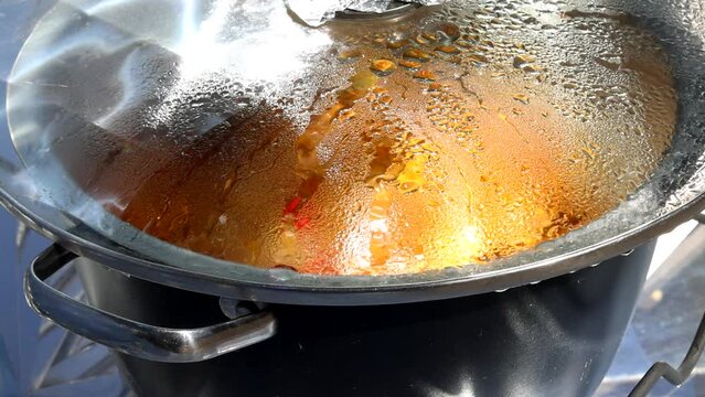 Cooking with sun energy, parabolic solar oven in the middle of cooking a dish thanks to solar energy