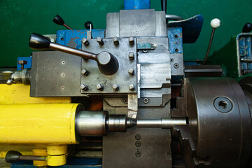 Mechanical processing of metal on a lathe, close-up. The steel bar is clamped in the lathe and the cutter is brought in.