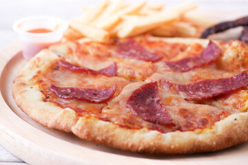 Slice of cheese pizza on a plate on wooden table.