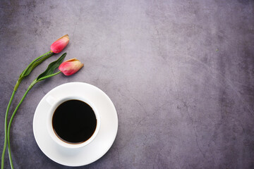 flat composition coffee, tulip flower on black background .