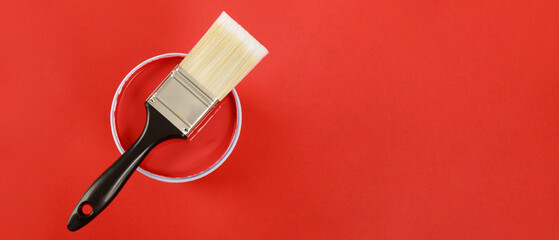 The cans of interior wall paint is placed on a red background.
