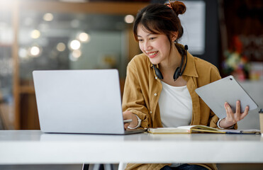 Student learning on laptop indoors- educational course or training, seminar, education online concept, Asian woman with modern laptop and headphones learning at home