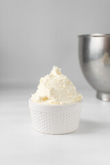 American buttercream in a white ramekin, buttercream with air pockets, textured buttercream in hobnail bowl