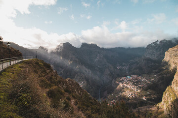 Very well-known tourist destination, Curral das freiras, a village nestled in the mountains with minimal sunlight. Aerial view of valley of nuns at sunset and peak of mountains in fog