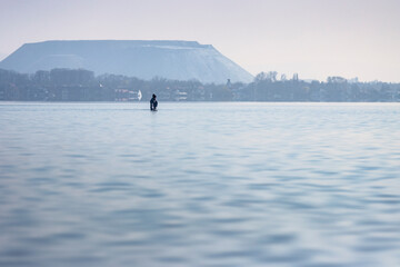 Blick von Mardorf auf einen Schatzsucher im Steinhuder Meer im Hintergrund der Kaliberg