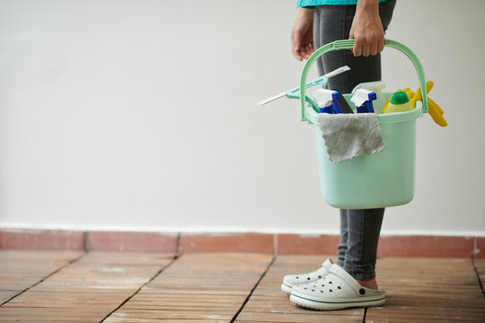 Cleaning service worker or maid holding bucket with detergents and tools