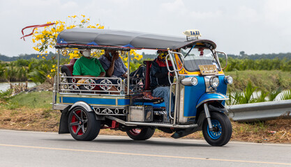  A traditional motor tricycle - tuk tuk rides on a rural road,Thailand