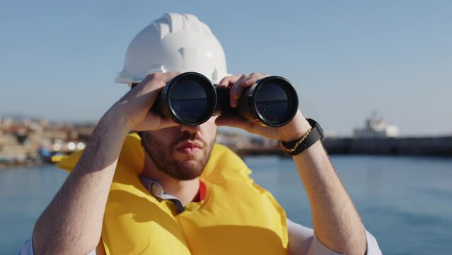 sailor watching with binoculars close up 