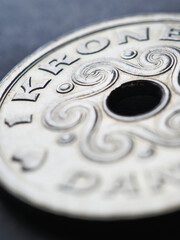 1 Danish krone coin closeup. National currency of Denmark. Vertical money illustration for news about economy or finance. Loan and credit. Tax and inflation. Macro