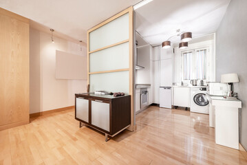 Kitchen of a short-term rental apartment with light-colored parquet floors