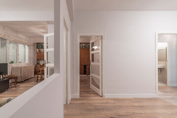 Fototapeta na wymiar Passage room with hole in the gray wall, chestnut wood floors and wooden furniture