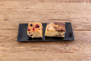 Marble cake and another with berries on a wooden table