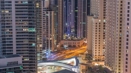 Overview to JBR and Dubai Marina skyline with modern high rise skyscrapers waterfront living apartments aerial night to day timelapse