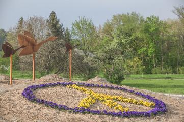 Skulptur fliegende Gänse an Kreisverkehr in Neckartenzlingen mit Peace-Zeichen aus Stiefmütterchen