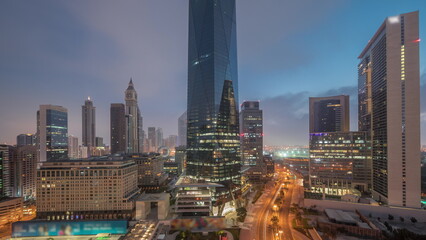 Fototapeta premium Dubai International Financial district aerial night to day timelapse. Panoramic view of business office towers.